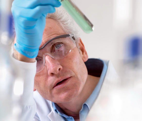 Scientist looking into test tube as he works on ASEA products