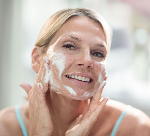 Woman applying RENU Advanced Skin Care